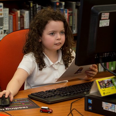 Girl sitting coding at a computer during a Code Club session At Kirkcaldy Library in Fife